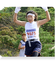 여성 한분이 두손을 들고 마라톤을 하고 있는 모습